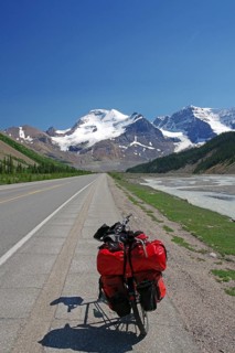 Loaded red touring bike on straight road