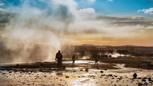 Visitors between steaming springs in the high temperature area Haukadalur