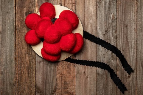 Original Black Forest Bollen hat in front of rustic wooden wall