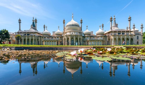 Royal Pavilion palace reflected in a pond with water lilies