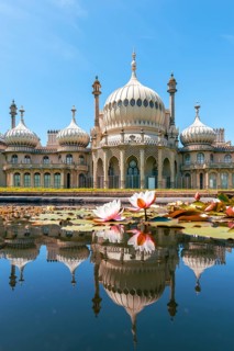 Royal Pavilion palace reflected in a pond with water lilies