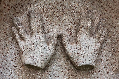 Symbol of blessing priest hands on a gravestone