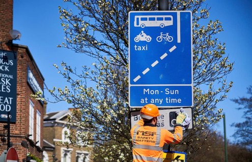 Construction worker cleaning traffic sign