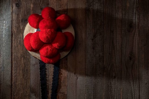 Original Black Forest Bollen hat in front of rustic wooden wall