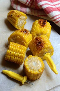 Roasted corn on the corn cob with corn on the cob holder