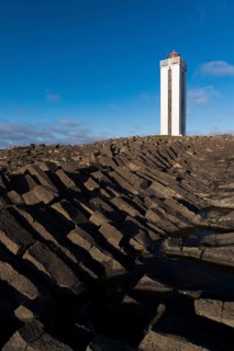 Lighthouse and coastal landscape with basalt formations
