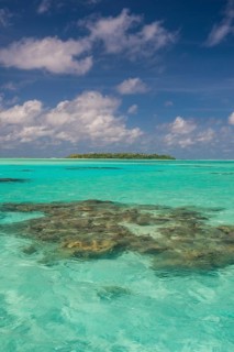 Little island in the turquoise waters in the Aitutaki lagoon