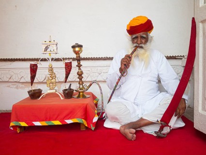 Elderly Indian man with turban smoke hookah