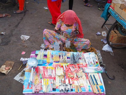 Vendor offering household appliances at market stall