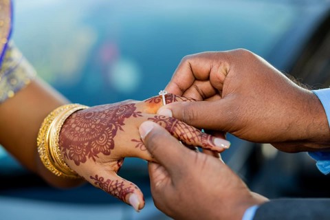 Engagement ring ceremony of a Mauritian Hindu couple. Groom passing ring in his bride`s finger