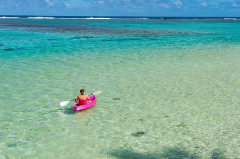 Woman kayaking in the turquoise waters of Rarotonga