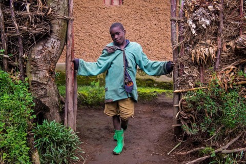 Young boy standing at the doorsteps of mud hut