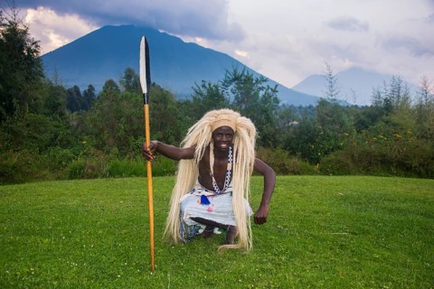 Man wears a wig carries a spear at a ceremony of former poachers