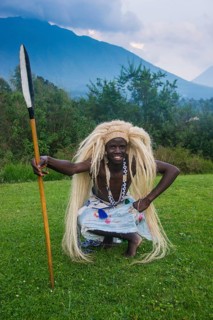 Man wears a wig carries a spear at a ceremony of former poachers