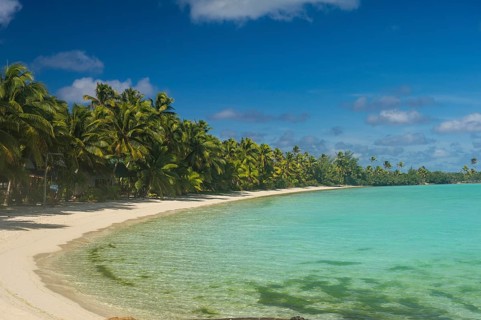 White sand beach and palm fringed beach in Aitutaki lagoon
