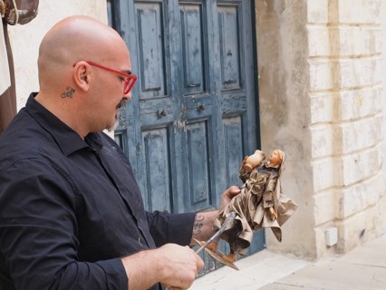 Artist creates a statue of a saint in the traditional way