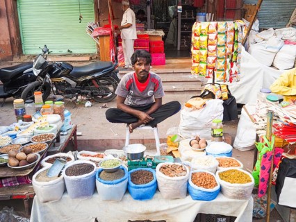 Vendor offering pulses at market stall