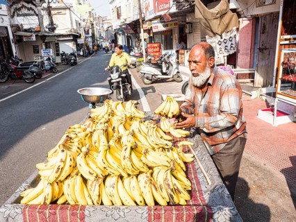 Vendor offering bananas at market stall