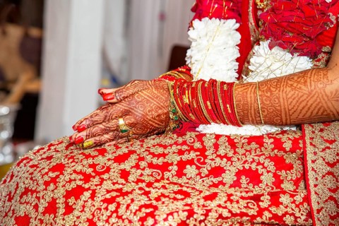 Traditional bridal jewelry and henna decoration on the hands of the bride during a religious ceremony at a Hindu wedding