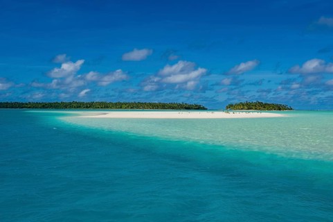 White sand beach and palm fringed beach in Aitutaki lagoon