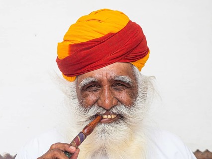 Elderly Indian man with turban smoke hookah
