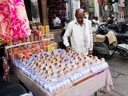 Vendor offering jewellery at market stall