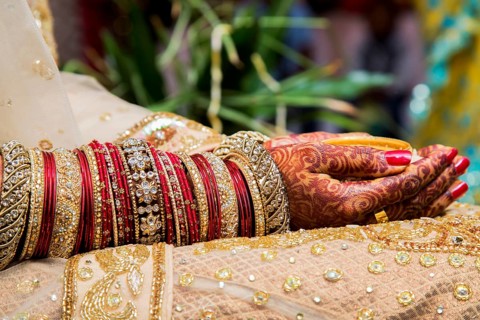 Traditional bridal jewelry and henna decoration on the hands of a bride during a religious ceremony at a Hindu wedding