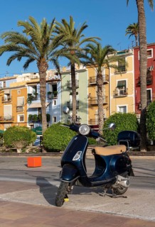 Vespa scooter in front of Colorful beachfront houses