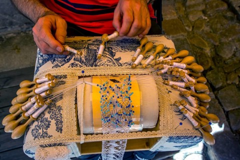 Man making traditional French lace before his shop