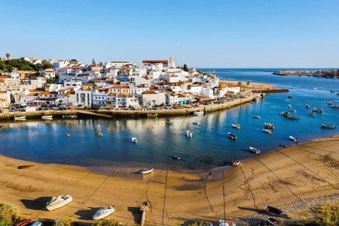 Aerial cityscape of white washed Ferragudo by Arade River