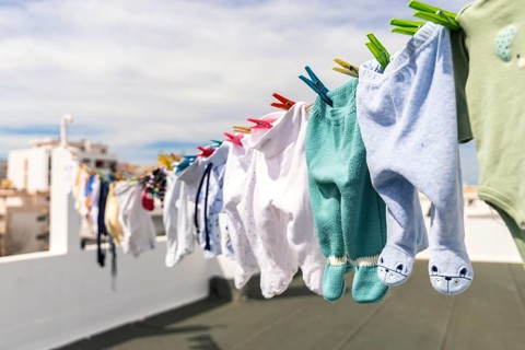 A lot of baby clothes drying on the roof in the city
