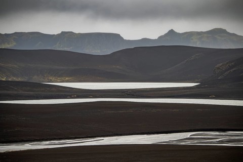 River and lakes in black lava desert