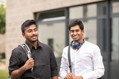 Students outside with bag in front of the university