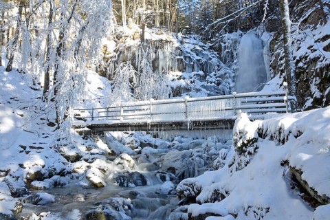 Bridge with icicles and icy waterfall