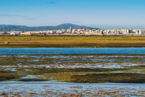 City of Faro seen from Faro Beach Peninsula with wetlands of Ria Formosa in between