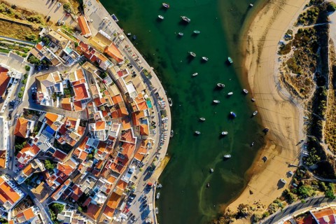 Aerial cityscape of white washed Ferragudo by Arade River