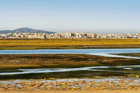 City of Faro seen from Faro Beach Peninsula with wetlands of Ria Formosa in between