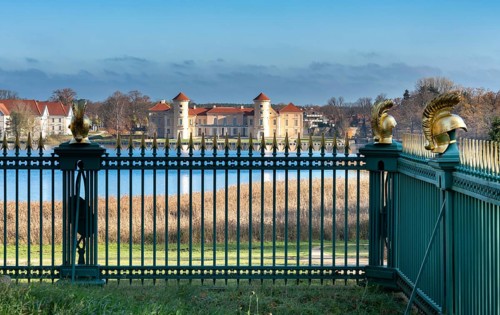 Restored fence with gold helmets at the Lake Grienerick obelisk in Rheinsberg