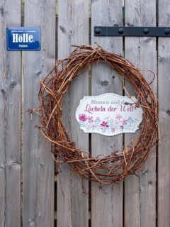Woven wreath with sign Hell on a wooden door at the Schlossberg in Quedlinburg