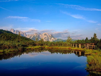 The peaks of the Gosaukamm are reflected in the moor lake at Loeckermoos