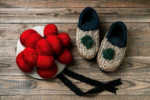 Original Black Forest Bollen hat with straw shoes on wooden background