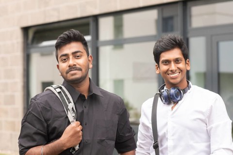 Students outside with bag in front of the university