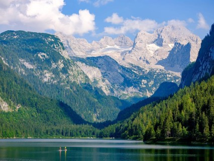 2 standup paddle boarders in Lake Gosau with a view of the Dachstein massif with the Gosau glacier