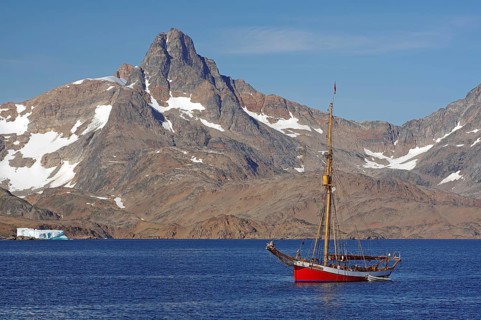 Sailing ship Dagmar Aaen in front of barren mountains
