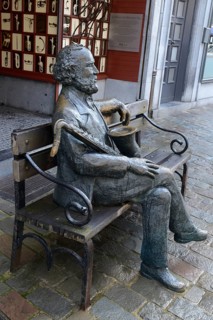 Sculpture of Adolphe Sax with saxophone in front of his birthplace
