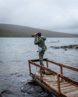 Hiker photographed on a wooden footbridge above Lake Leitisvatn