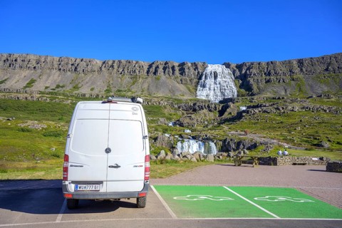 Camping bus next to parking spaces reserved for e-cars