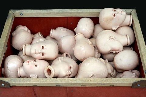 Doll heads without eyes in a box for a doll clinic