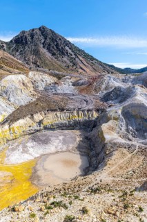 Crater with yellow discoloured sulphur stones and colourful mineral deposits