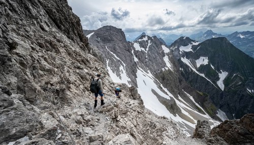 Hiker and woman descending rocky terrain